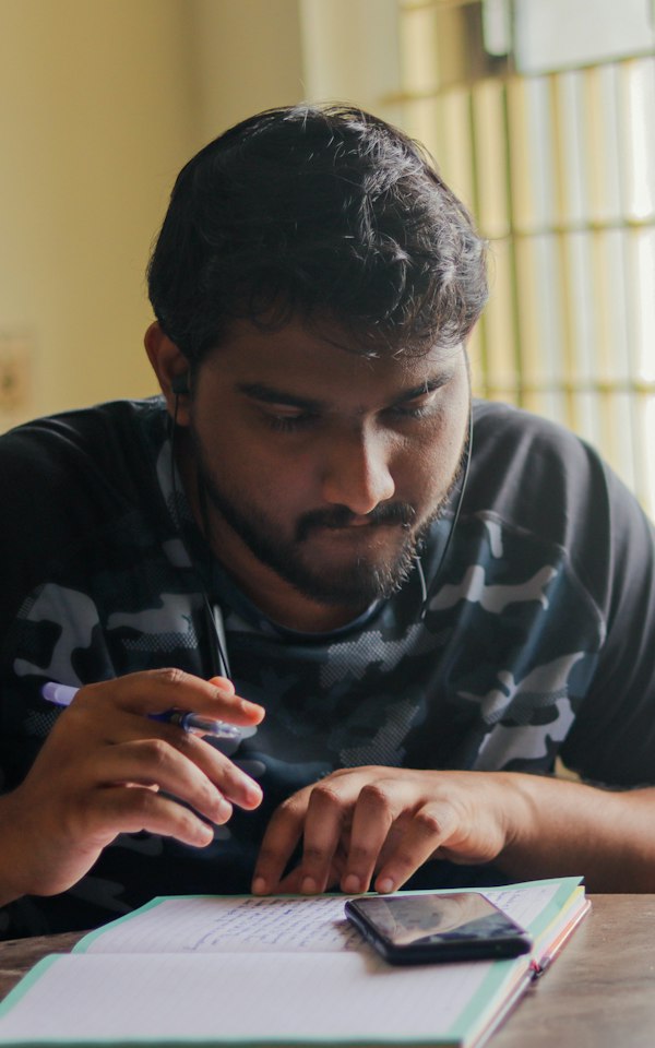Student taking notes at a desk