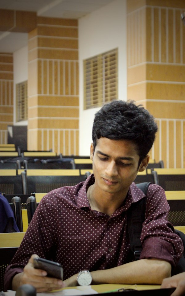 Student looking at his phone in a study hall