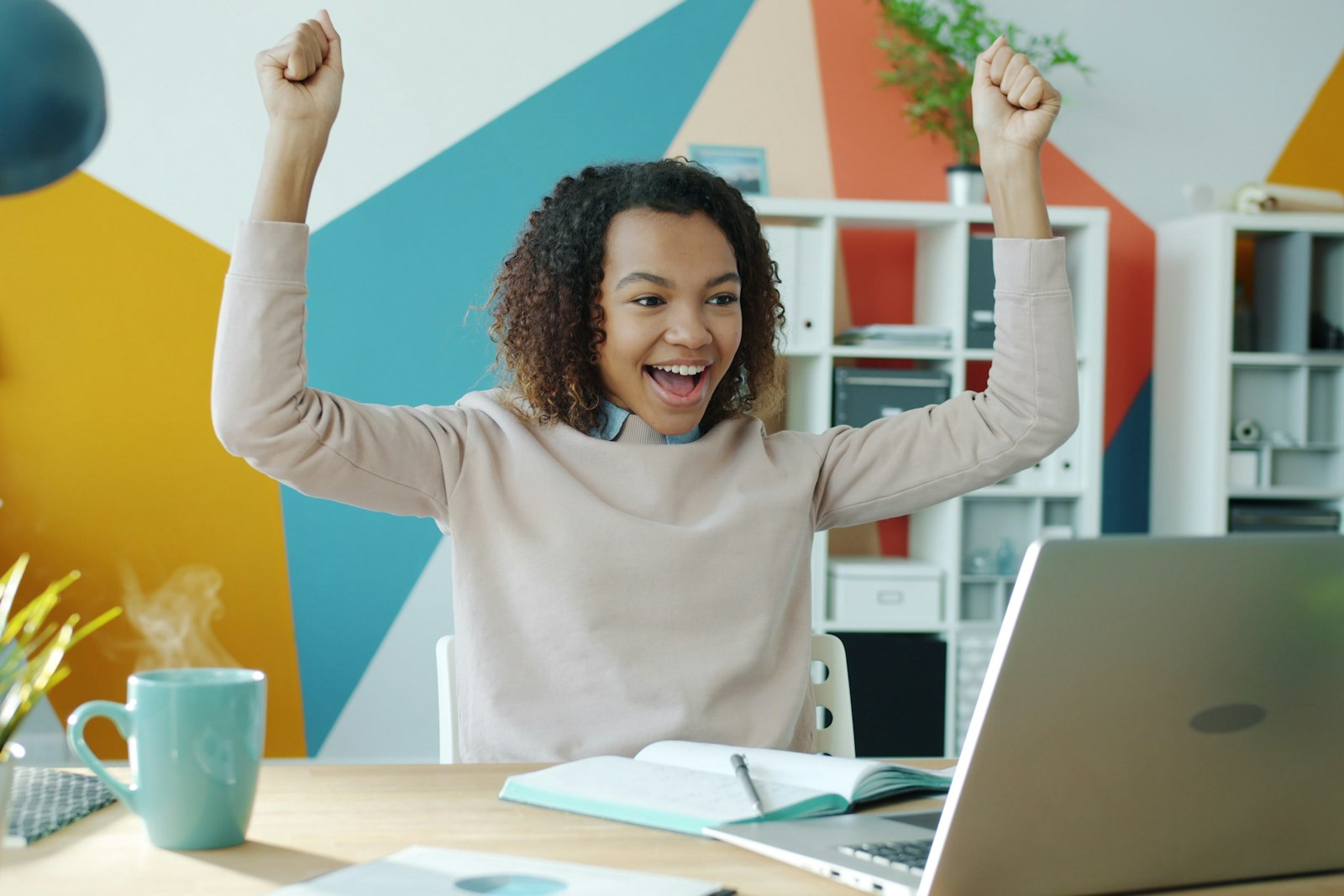 Student celebrating at her desk